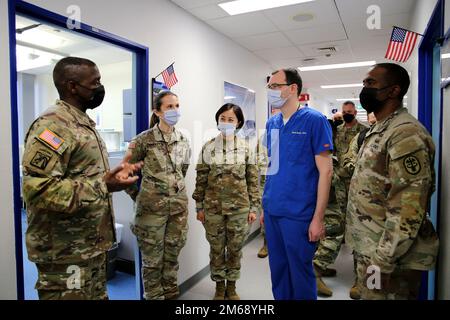 Lt. Gen. R. Scott Dingle, left, surgeon general of the Army and Medical Command commanding general, presents a coin at SHAPE Dental Clinic to Maj. Daniel D. Becker, second from right, dentist, April 20, 2022 at SHAPE Healthcare Facility in Casteau, Belgium. Stock Photo