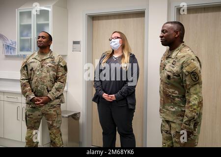 U.S. Army Medical Command Command Sgt. Maj. Diamond D. Hough, left, and Lt. Gen. R. Scott Dingle, right, surgeon general of the Army and MEDCOM commanding general, award Jodie Canez, animal care technician, a coin April 20, 2022 at Chièvres Veterinary Clinic at Chièvres Air Base, Belgium. Stock Photo