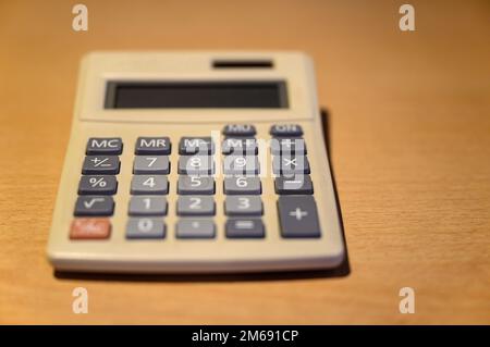Electronic calculator on a desk. Basic solar desk calculator representing old technology. Focus on number 8 with shallow depth of field. No branding. Stock Photo