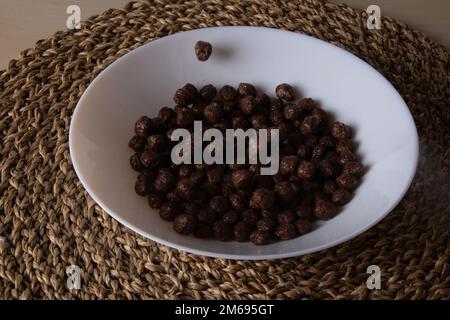 photo many small chocolate balls in a round white plate top view Stock Photo