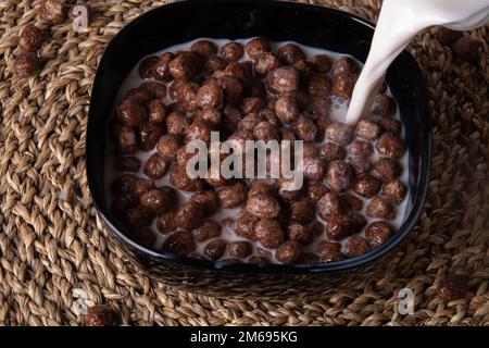 photo of a quick breakfast with milk in a plate on a straw napkin Stock Photo