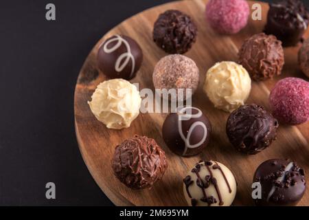 photo multicolored chocolates on a wooden board in close-up Stock Photo