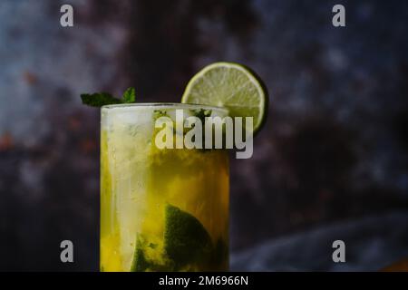 Homemade Mango Mojito in a tall glass jar on dark background, selective focus Stock Photo