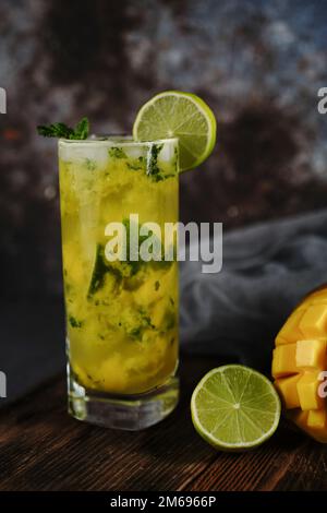 Homemade Mango Mojito in a tall glass jar on dark background, selective focus Stock Photo