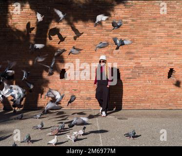 Chiang Mai, Thailand. November 13, 2022:Tourists posing with pigeons near Pratu Tha Phae Gate. Chiang Mai is northern Thailand's most colorful travel Stock Photo