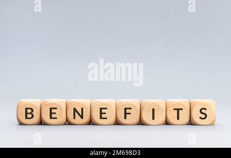 Benefits word on wooden blocks on gray background. Copy space Stock Photo