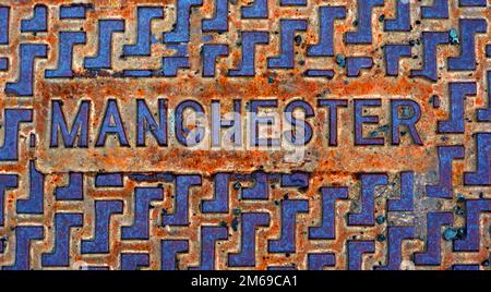 Rusty Manchester cast iron embossed grid, street utility cover Stock Photo