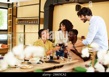 The best friends in the restaurant are making a toast with red wine. Celebration concept. Stock Photo