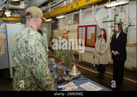 PERTH, Australia (April 20, 2022) Senior Chief Electrician's Mate Christian Decastro, from San Jose, California, assigned to the Emory S. Land-class submarine tender USS Frank Cable (AS 40), explains the ship's repair capabilities to local distinguished visitors during a tour of the ship at HMAS Stirling Navy Base, April 20, 2022. Frank Cable is on patrol conducting expeditionary maintenance and logistics in support of national security in the U.S. 7th Fleet area of operations. Stock Photo