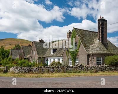 Row of farm cottages in Hethpool near Kirknweton, Northumberland. Designed in the arts and crafts style and completed in the 1920s. The village of Het Stock Photo