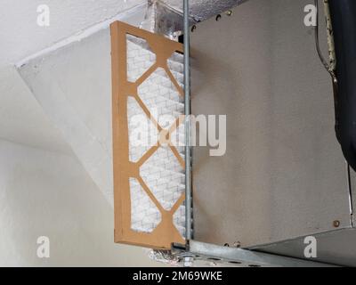 Changing HVAC air filter in residential heating and air conditioning system. Home air duct ventilation system maintenance for clean air. Stock Photo