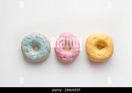 Three Colorful delicious donuts isolated on white background Stock Photo