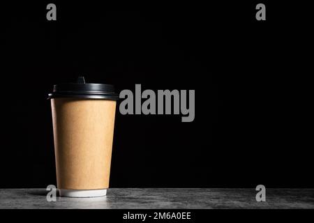 Brown Paper cup of coffee or tea on a black background with copy space, mock up Stock Photo