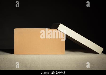 Front view on open brown cardboard box on black background, copy space Stock Photo