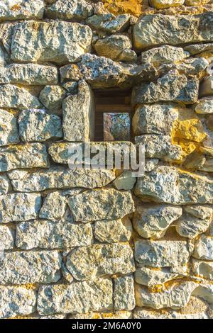 Textured stonework on filled-in doorway of old barn, tree decorations in market square, sud-Touraine, France. Stock Photo
