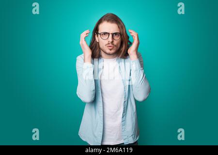 Portrait of shocked man wearing casual cloth eyeglasses open mouth isolated on blue color background. Stock Photo