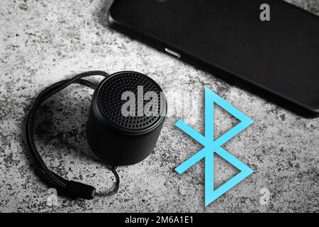 Black mini Bluetooth speaker and smartphone conected with Bluetooth Stock Photo