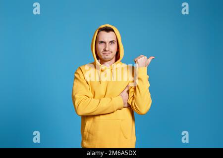 Cheerful handsome man pointing at copy space Stock Photo