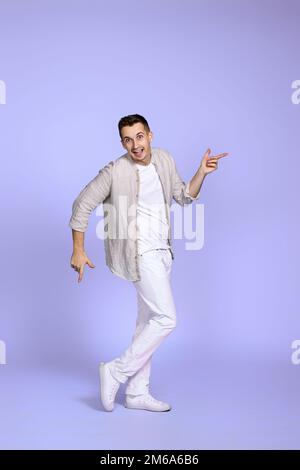 happy man dancing on pastel violet background. Stock Photo