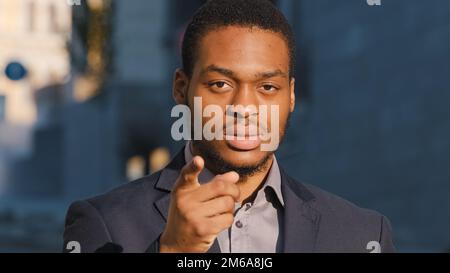 Close up African American professional businessman employer man manager lawyer guy ethnic male hr manager make hand gesture pointing hey you looking Stock Photo