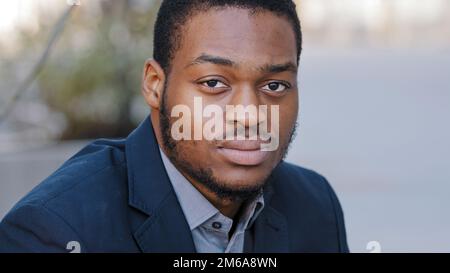 Close-up male portrait in city headshot thoughtful sad serious upset worried calm ethnic guy upset millennial man looking at camera businessman Stock Photo