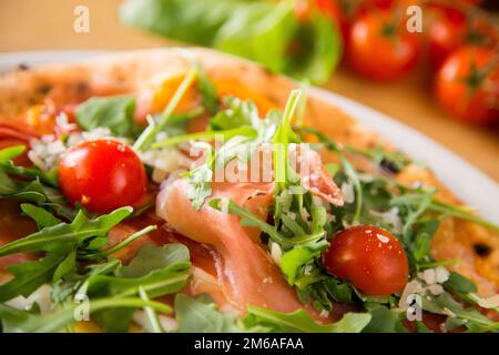 Salmon Pizza. Neapolitan pizza made with salmon and baked vegetables. Italian vegetarian recipe. Stock Photo