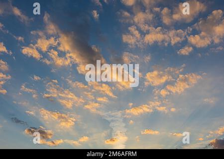 Sunbeams light up fluffy clouds against a cobalt blue sky at twilight in Georgia. Stock Photo