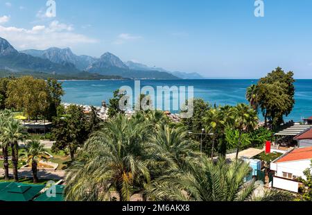 Sunshades and chaise lounges on beach. Turkey, Kemer. Beautiful view of mountains and sea from embankment