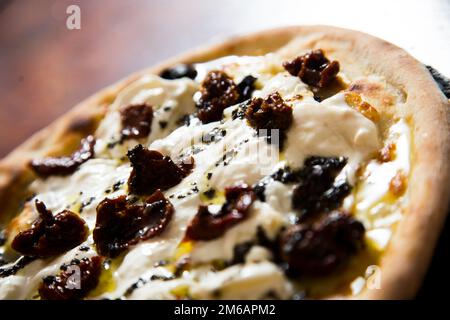 Bufala and black olives Pizza. Neapolitan pizza made with tomato sauce, mozzarella cheese and some vegetables. Italian recipe. Stock Photo