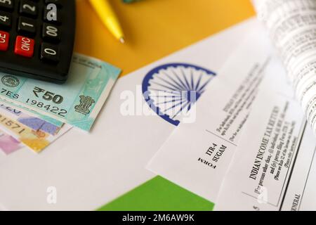 KYIV, UKRAINE - MAY 4, 2022 Indian income tax return blank form with pen and indian rupees bills on indian country flag close up. Annual tax report concept Stock Photo