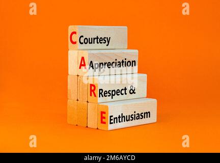 CARE symbol. Concept words CARE courtesy appreciation respect and enthusiasm on wooden block on beautiful orange background. Business CARE courtesy ap Stock Photo