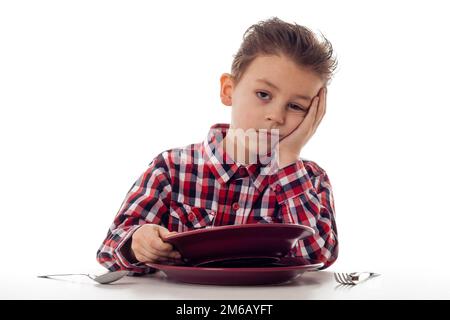 Tired boy at dining table Stock Photo