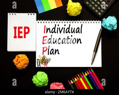 IEP individual education plan symbol. Concept words IEP individual education plan on white note on a beautiful black background. Calculator. Business Stock Photo