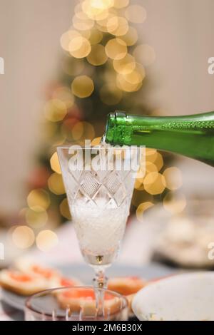 A glass of champagne on a table against Christmas tree Stock Photo