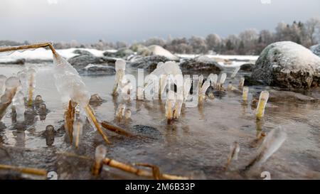 various ice formations on rocks and sandbars on the seashore, ice ...