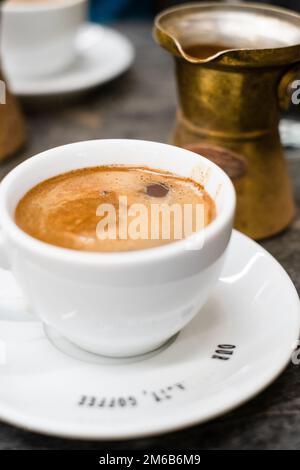 https://l450v.alamy.com/450v/2m6b6m9/traditional-greek-coffee-ellinikos-kafes-athens-greece-a-cup-and-saucer-holds-the-coffee-with-a-frothy-top-kaimaki-and-a-briki-the-pot-used-to-2m6b6m9.jpg