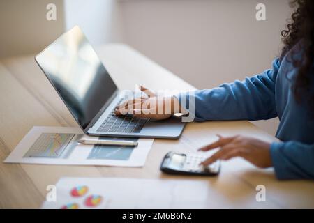 Close up focus on female hands making calculations on laptop Stock Photo
