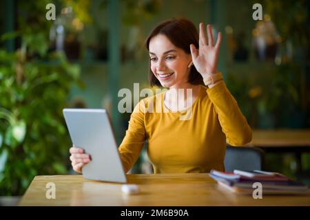 Attractive woman sitting at coffee shop, using touch pad Stock Photo