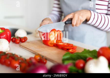 Female hands cutting fresh vegetables on chopping board Stock Photo