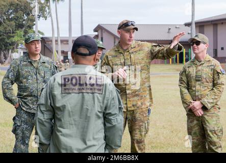 Royal Australian Air Force Squadron Leader Mark Rankin, asks a question to U.S. Army 39th Military Police Detachment Special Reaction Team Officer Joey Dela Cruz, during Pacific Defender 22-2 at Schofield Barracks, Hawaii, April 22, 2022. Pacific Defender attendees share force protection information and understanding of security operations contributing to regional security and stability through cooperation and information exchange among selected Indo-Asia-Pacific nations. Stock Photo