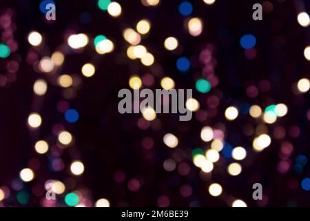Christmas glowing garland with defocused multicolored lights. Colorful holiday background. Happy new year background. Stock Photo