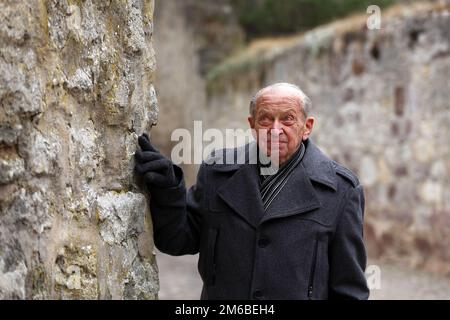 Elderly man standing at the city walls of a historic German town Stock Photo