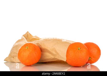 Three sweet organic tangerines with paper bag, macro, isolated on white background. Stock Photo