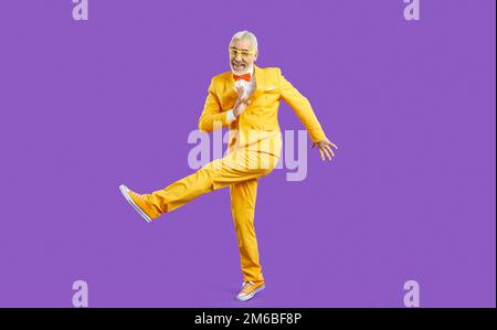Smiling energetic old man dancing in studio Stock Photo