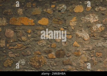 Horizontal stoned rock cobble stone wall with mortar for a textured background abstract material that is slightly dirty vintage and grunge non-uniform Stock Photo