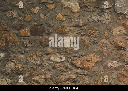 Horizontal stoned rock cobble stone wall with mortar for a textured background abstract material that is slightly dirty vintage and grunge non-uniform Stock Photo