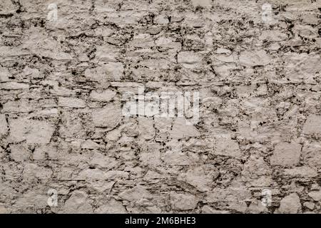 Horizontal stoned rock cobble stone wall white mortar for a textured background abstract material thats slightly dirty vintage and grunge non-uniform Stock Photo