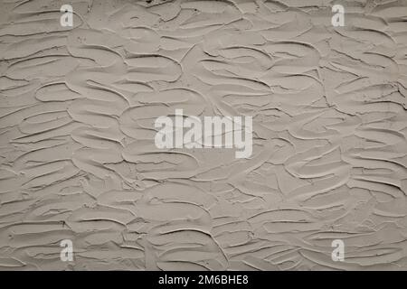 White wall or background of textured wavy stucco plaster material smeared onto surface creating a lovely design back and forth. Has shadows of black. Stock Photo