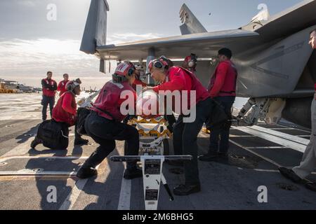 Sailors assigned to USS Gerald R. Ford’s (CVN 78) weapons department and the 'Blacklions' of Strike Fighter Squadron (VFA) 213,  load an F/A-18F Super Hornet with training ammunition on the flight deck, April 22, 2022.  Ford is underway in the Atlantic Ocean conducting carrier qualifications and strike group integration as part of the ship’s basic training phase. Stock Photo
