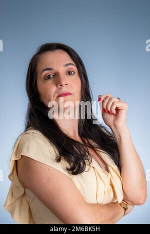 Young businesswoman, lawyer, with her hands close to her face. Isolated against light gray background. Stock Photo